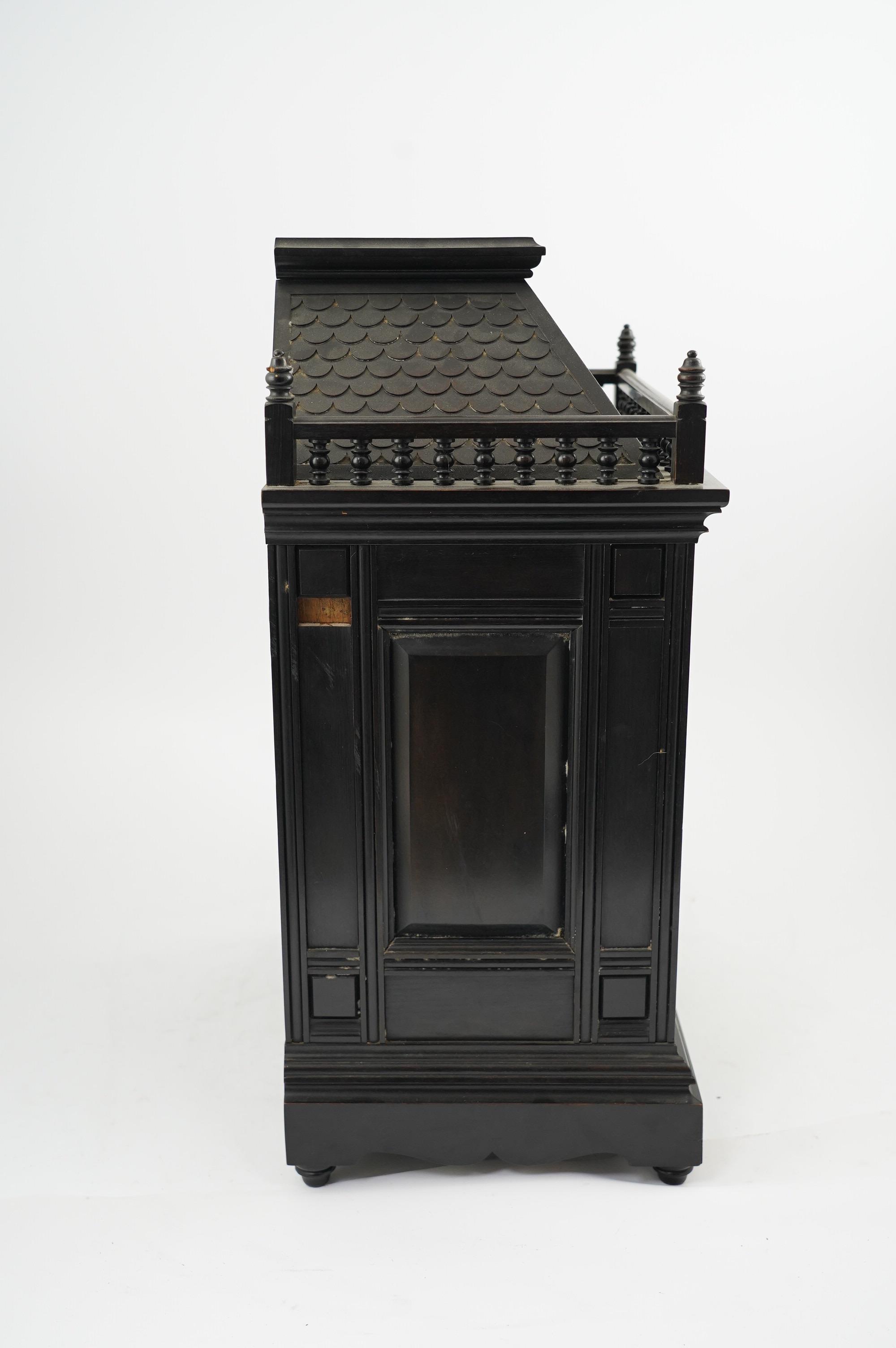 A Victorian Aesthetic Movement ebonised architectural mantel clock, probably designed by Lewis Foreman Day, the eight day chiming movement marked G.V. no. 39837, with Elourdelet lever, with figure and foliage decorated g